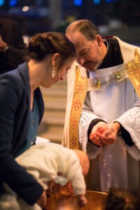 man in white dress shirt carrying baby in white dress